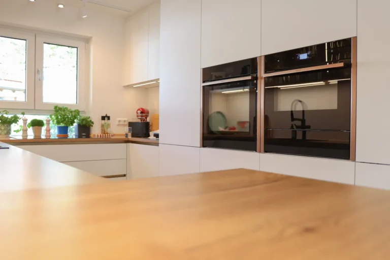 Eingelassene NEFF Backöfen mit bronzefarbenem Rahmen in einer grifflosen Designküche – geplant und umgesetzt in Karlsruhe-Durlach.