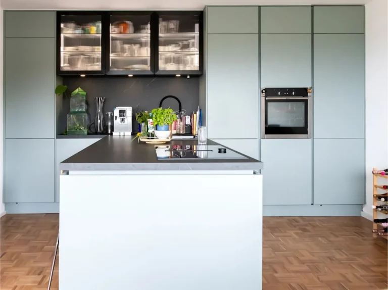 Offene Wohnküche mit Kochinsel, dunkler Arbeitsplatte und grifflosen Fronten in Eukaytpus