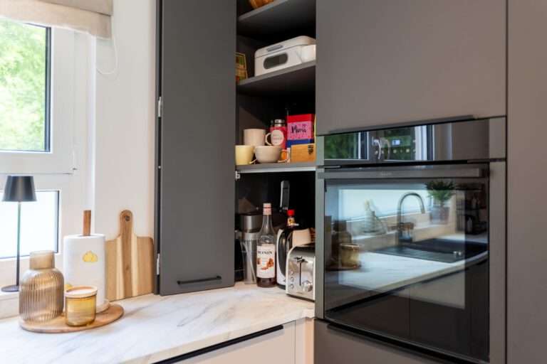 Faltaufsatzschrank neben dem Backofen als praktische Stauraumlösung für Kleingeräte und Vorräte.